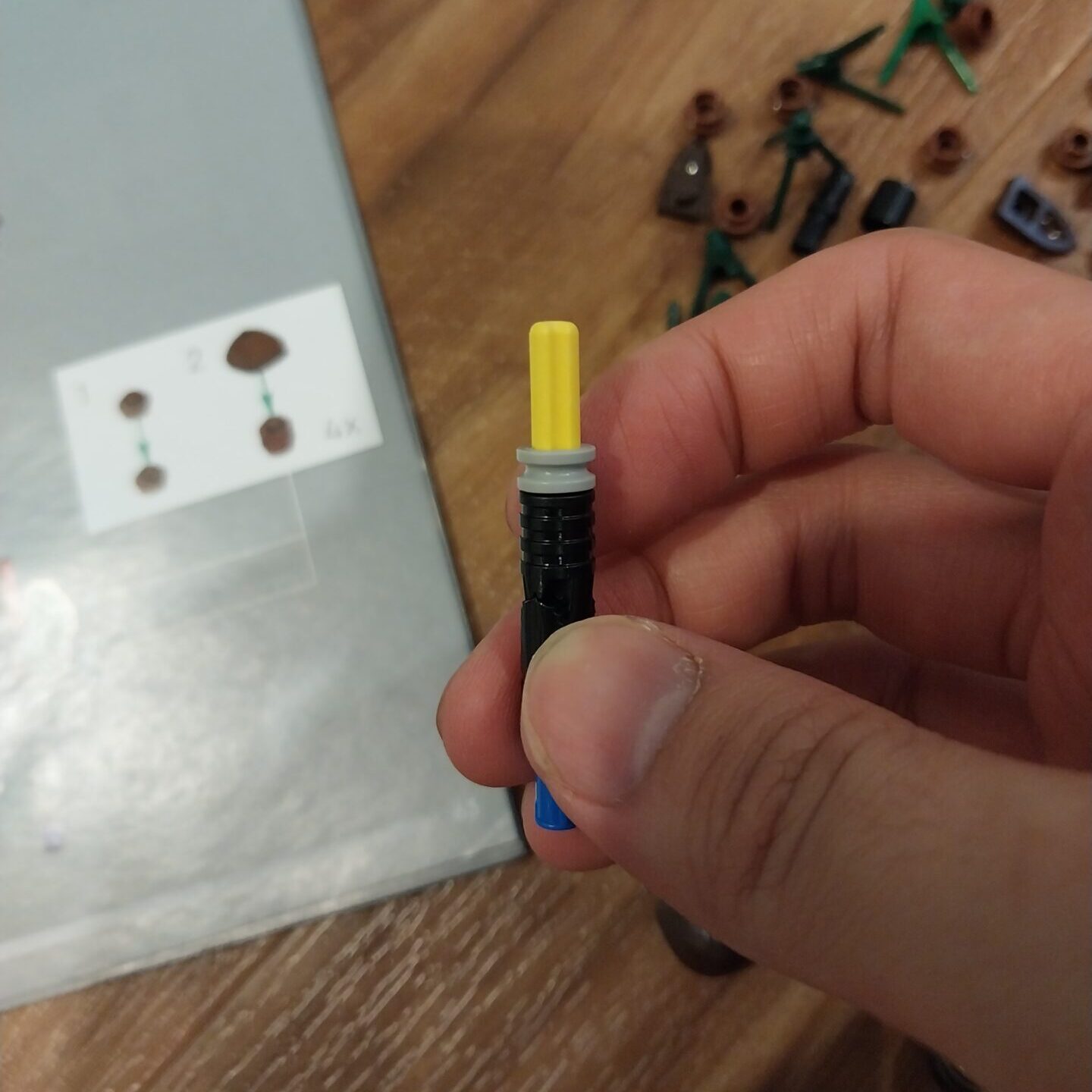 A yellow Lego axle. Threaded around it are more lego pieces.